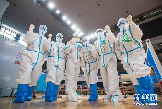 3月10日，武漢武昌方艙醫院正式休艙，醫護人員在送走新冠肺炎治愈患者后合影留念。新華社記者 肖藝九 攝
