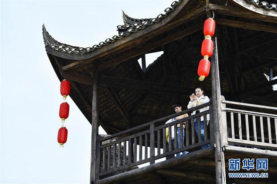  游客在重慶市武隆區黃鶯鄉復興村的觀(guān)景樓上欣賞田園景色（2019年3月28日攝）。 新華社記者 劉潺 攝