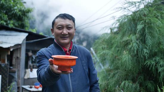  扎西巴珠展示他制作的木碗。新華網(wǎng) 旦增努布攝